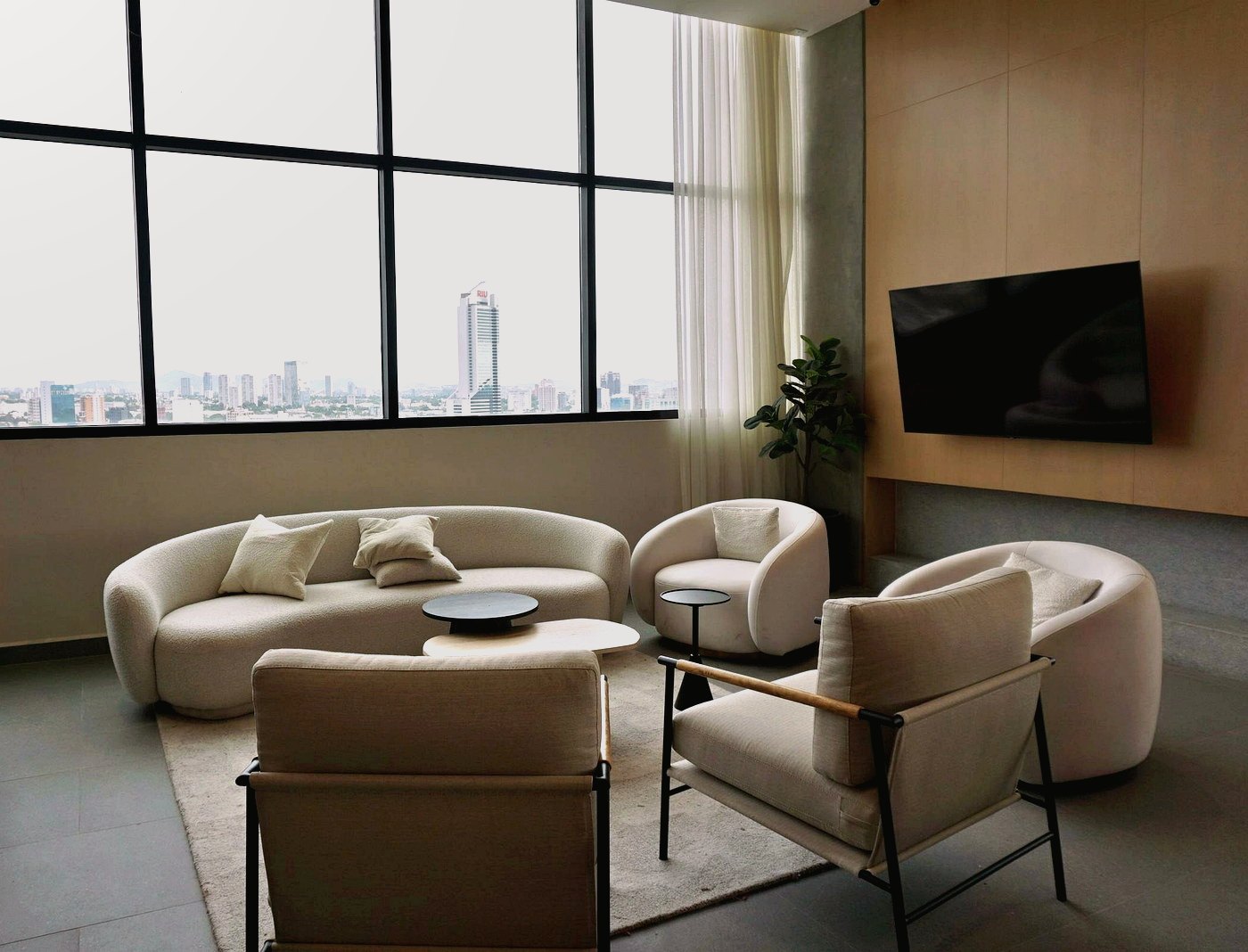 Phòng khách căn hộ dịch vụ Chapter9 với sofa, view thành phố và ánh sáng tự nhiên